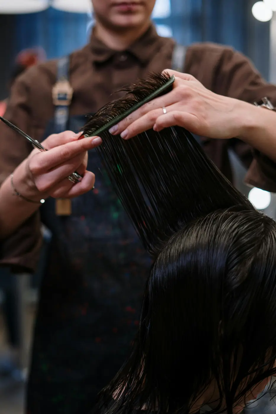 Stylist blending highlights at a Hattiesburg boutique salon — warm tones, professional styling station